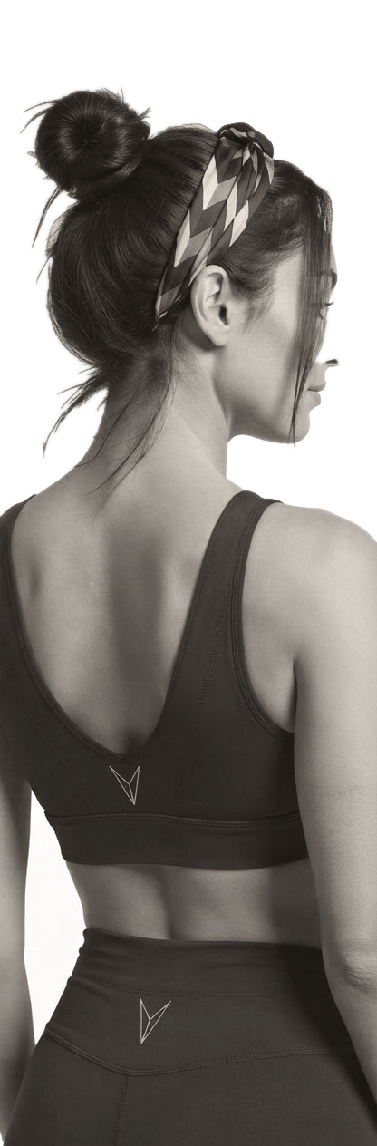 Femme de dos en brassière evryBODY, chignon et bandeau imprimé, le visage de profil